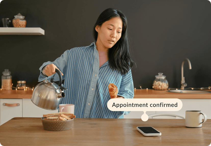 women checking her phone on the table with a label "Appointment confirmed" 