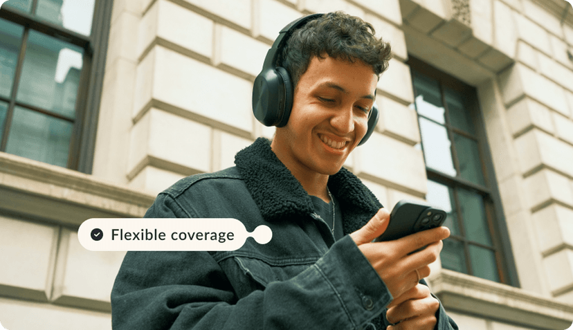 a young men smiling while looking at his phone
