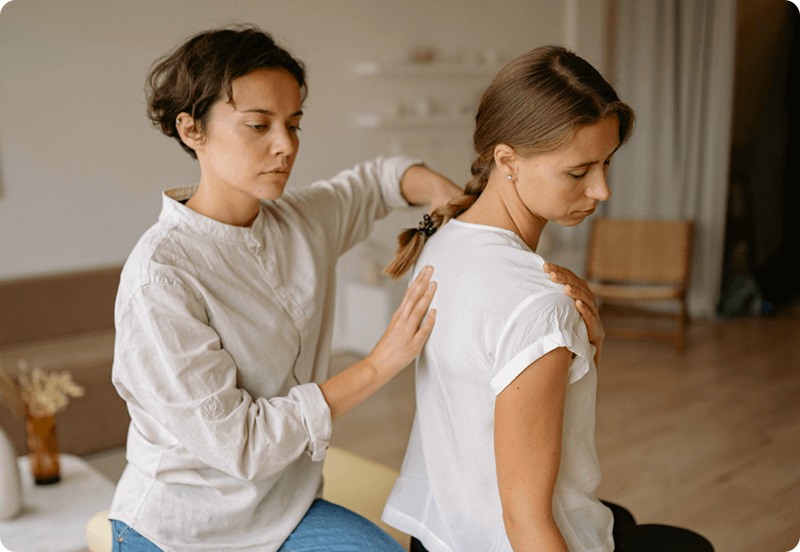 Woman exercising at a physiotherapist office, assisted by a specialist. 