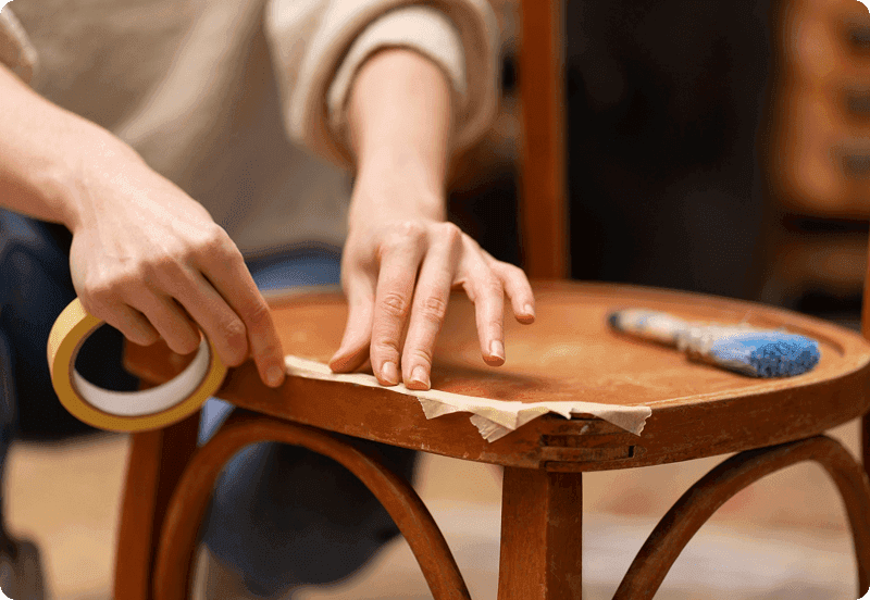 Person fixing their chair with tape after breaking it.