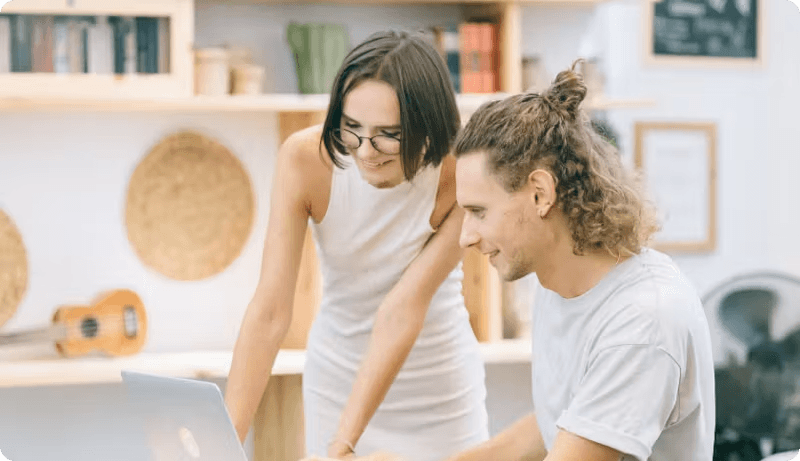Couple comparing English-language life insurance quotes for Germany at a laptop