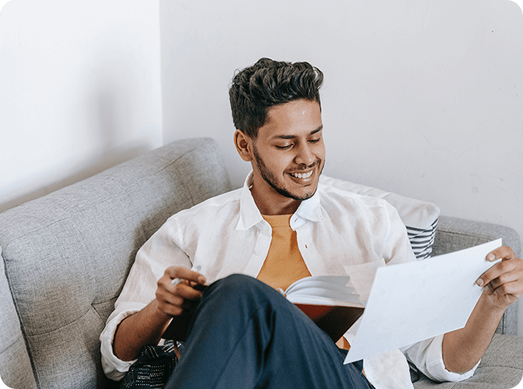 Person sitting on couch and reading papers.
