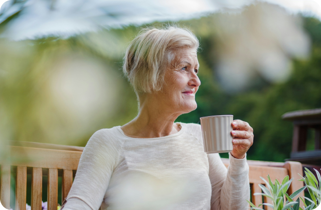 an elderly woman drinking her coffee