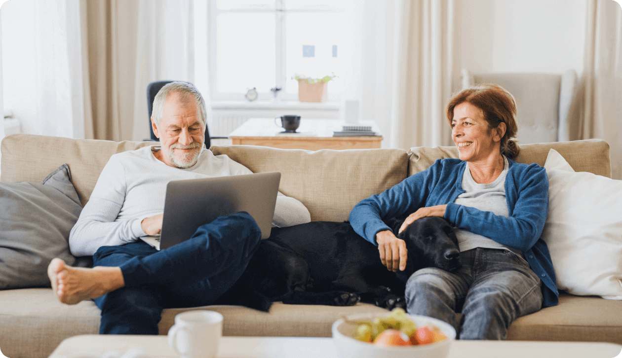 an elderly couple sitting on a couch at home