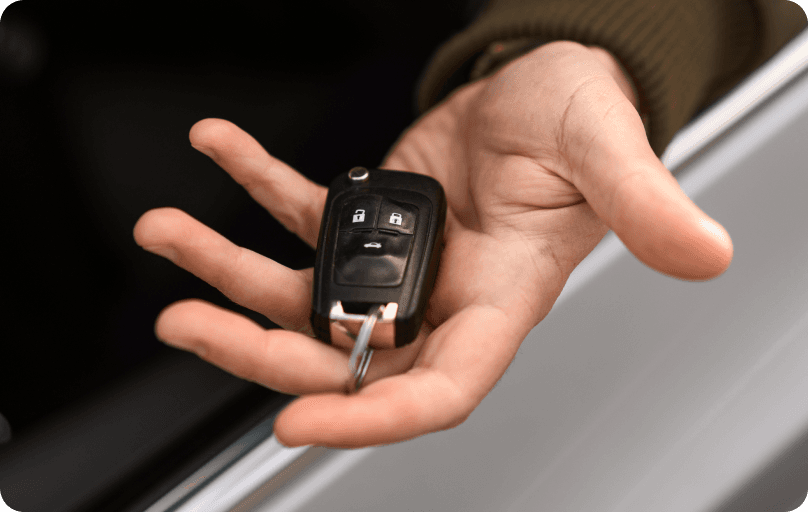 Person holding a car key.