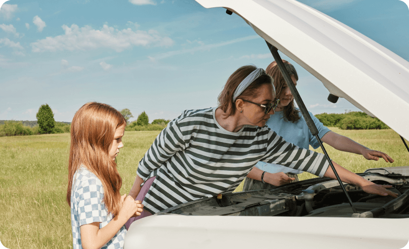 A mother and two daughters checking the engine of a white car parked with opened front bonnet.