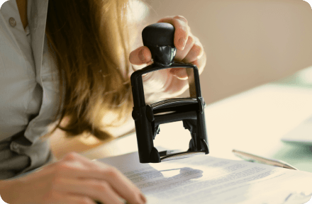 A public office representative approving documents with a stamp in Slovenia.