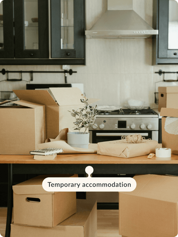 An apartment full of moving in boxes. The tag reads "Temporary accommodation".