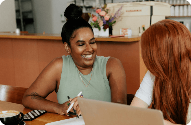 Two ladies talking while checking Feather's website