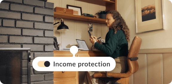 A woman working at her desk in Netherlands, adding income protection to her life insurance policy.
