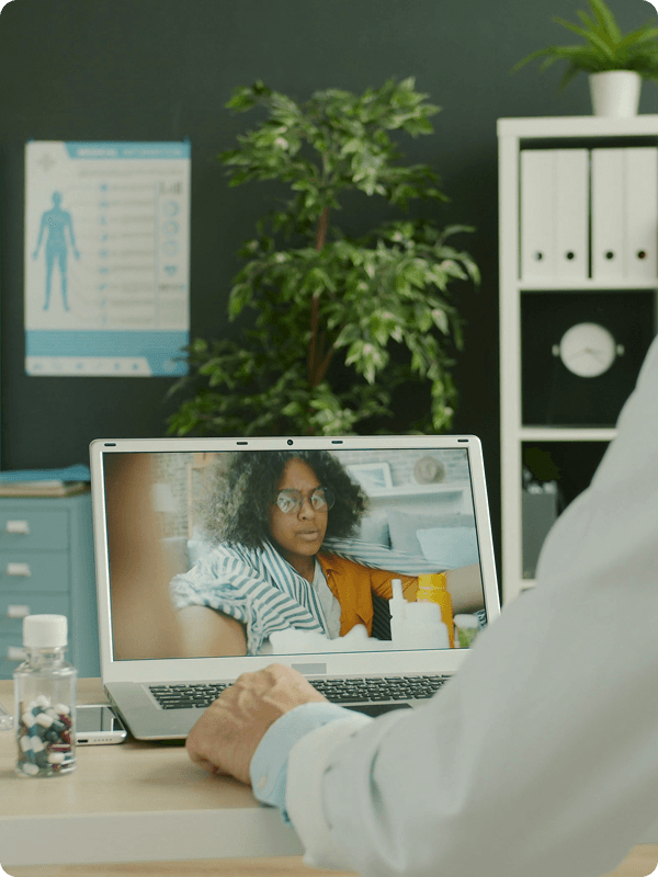 A sick person having a telemedicine video call with her doctor.