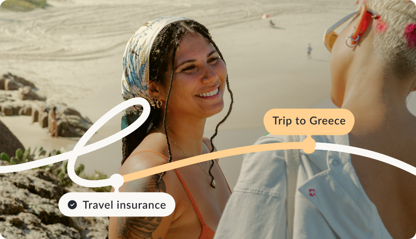 Two women on vacation, on a beach smiling. A graphic timeline reads "Travel insurance" marked with a checkmark and "Trip to Greece".